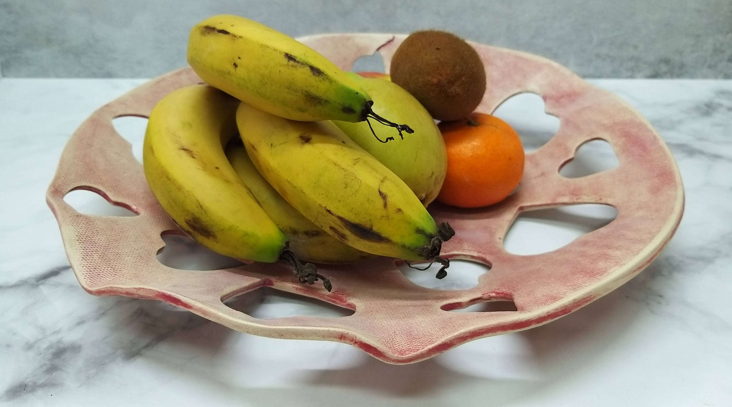 Faded red ceramic bowl with spread out 3cm heart-shaped cutouts suitable for Valentine's Day fruits