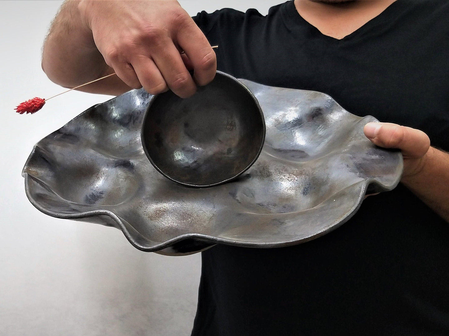 Rounded wavy black passover plate with central bowl and rust bronze blue metallic shades