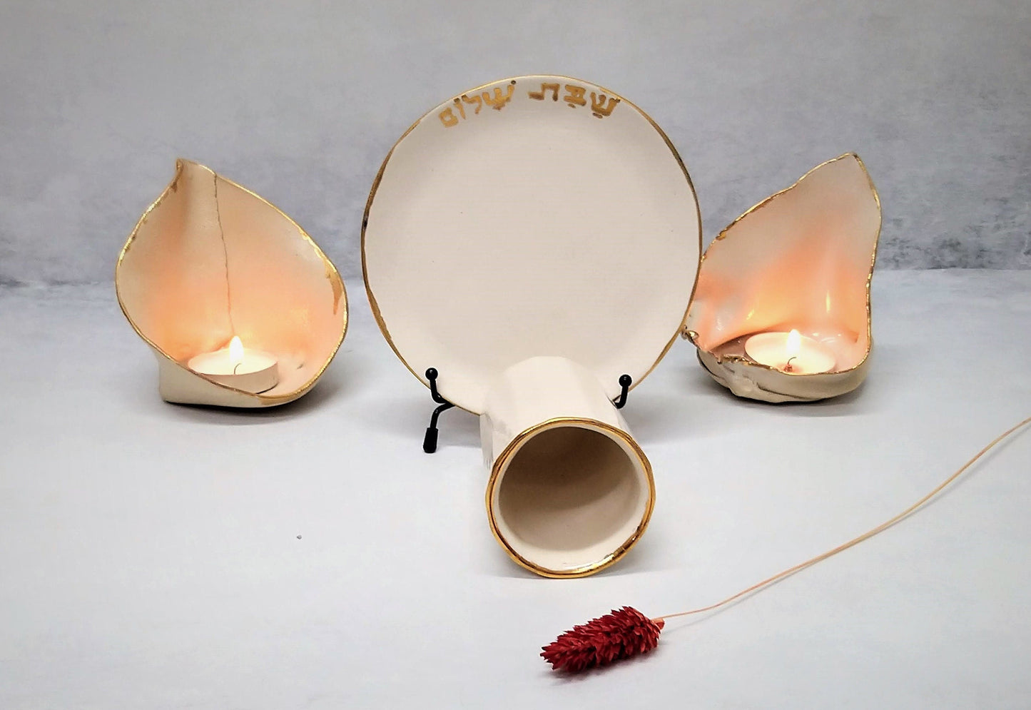 Ceramic kiddush cup and candlesticks on a table