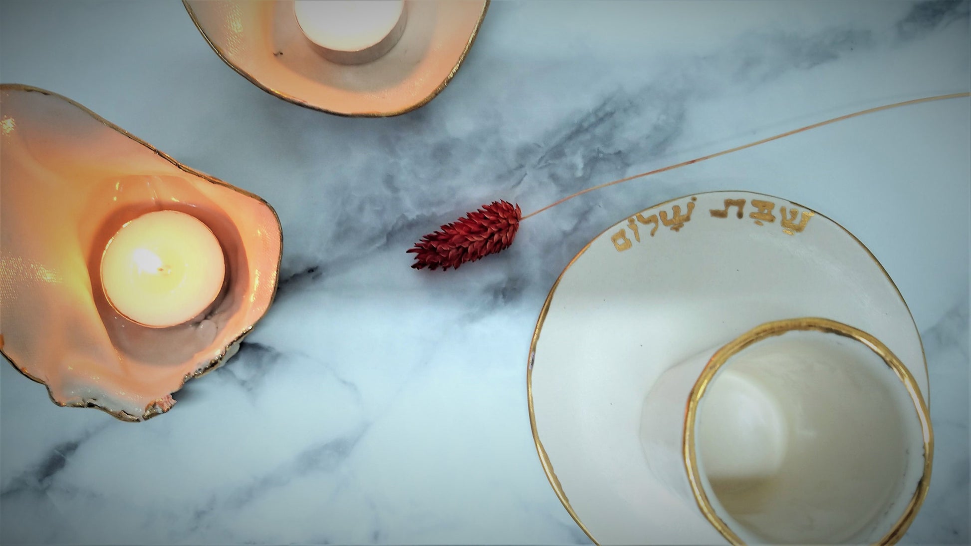 Ceramic kiddush cup with gold rim and Shabbat shalom write in Hebrew
