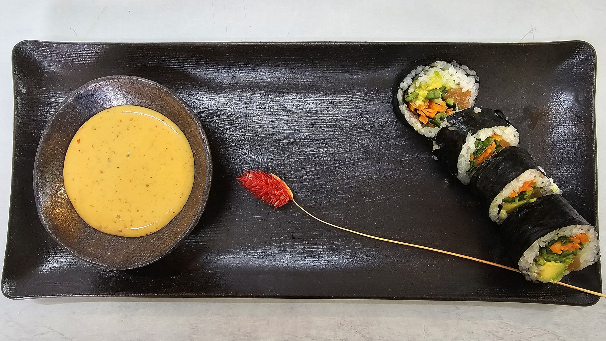Sauce bowl centered on black rectangular tray