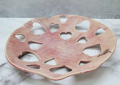 Bright red ceramic Valentine's Day bowl with rows of 3cm wide heart-shaped holes spaced out in lattice design