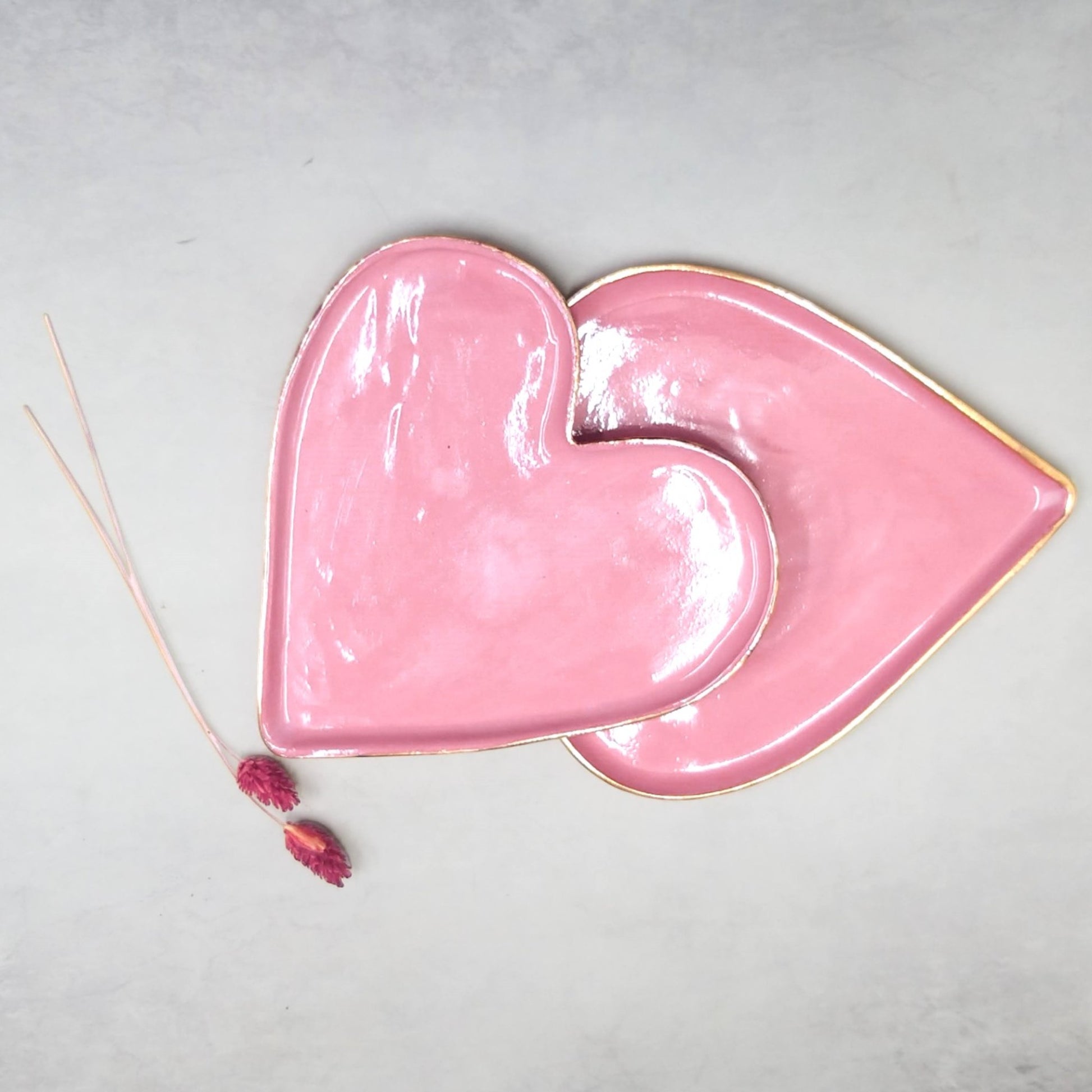 Two heart shape ceramic plates colored pink and gold