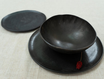 Layered black plates with wide bowl