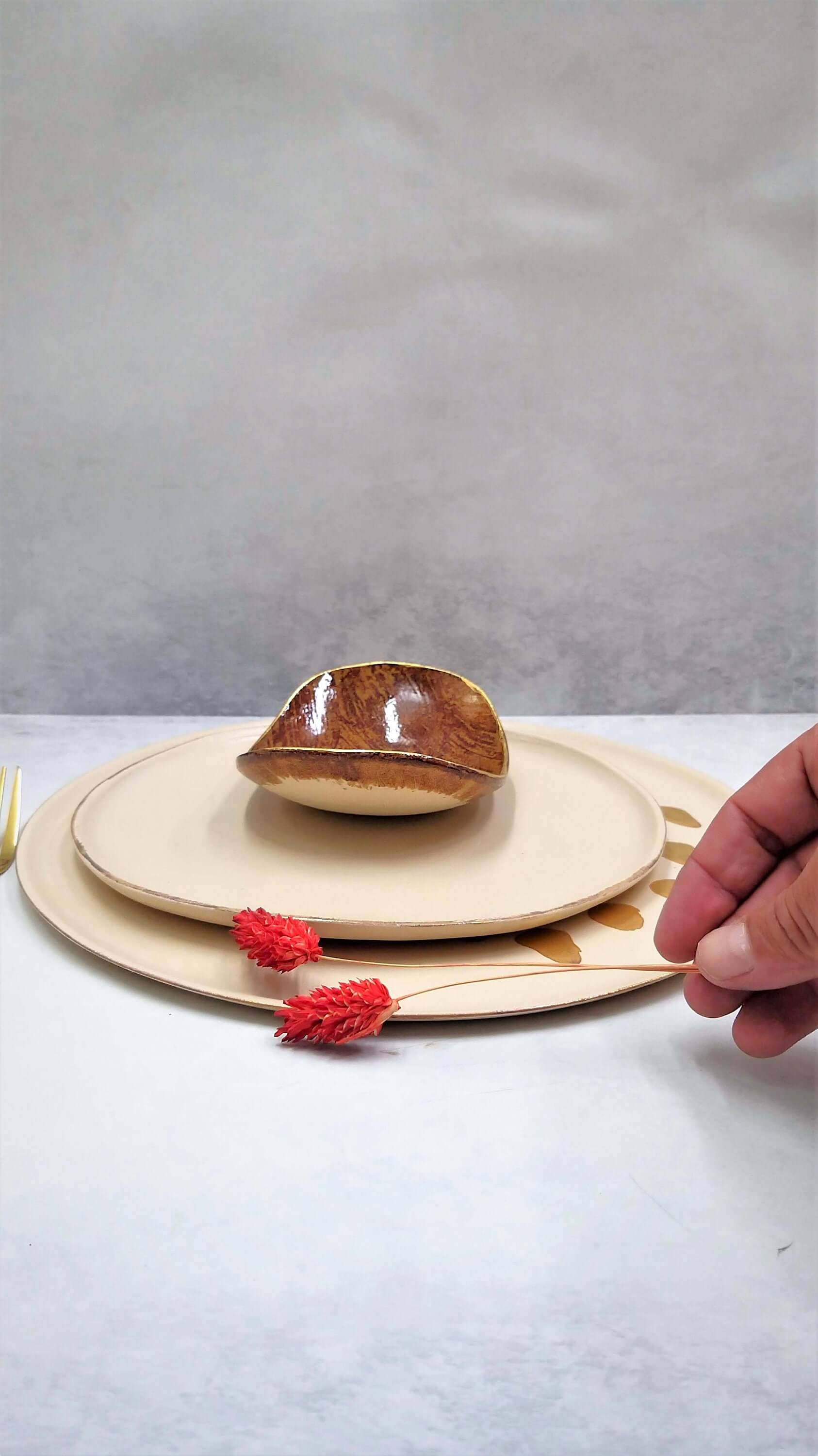 Artisan-crafted cream plate with hand-applied gold design