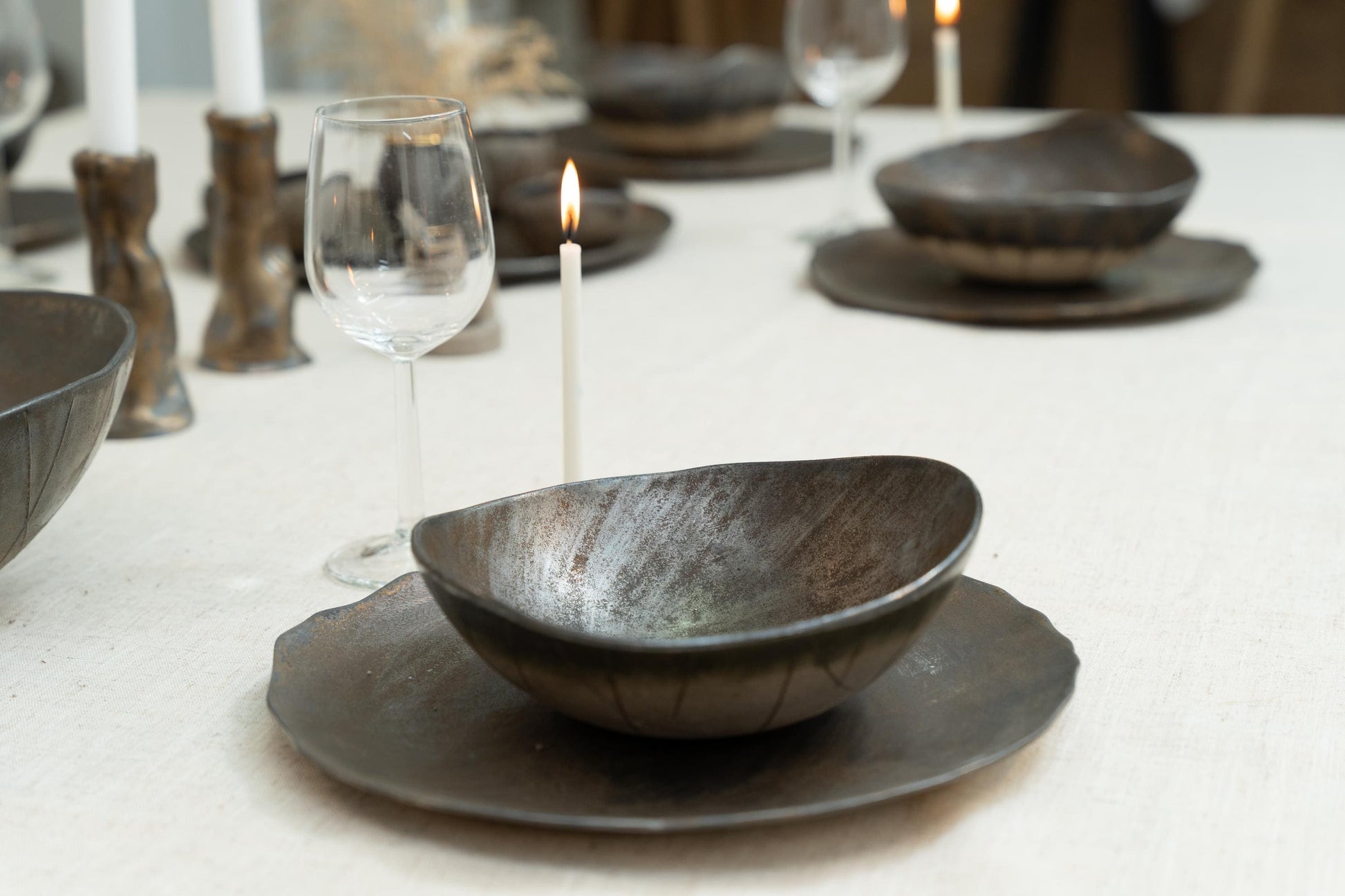 Handmade black ceramic bowl on rustic plate