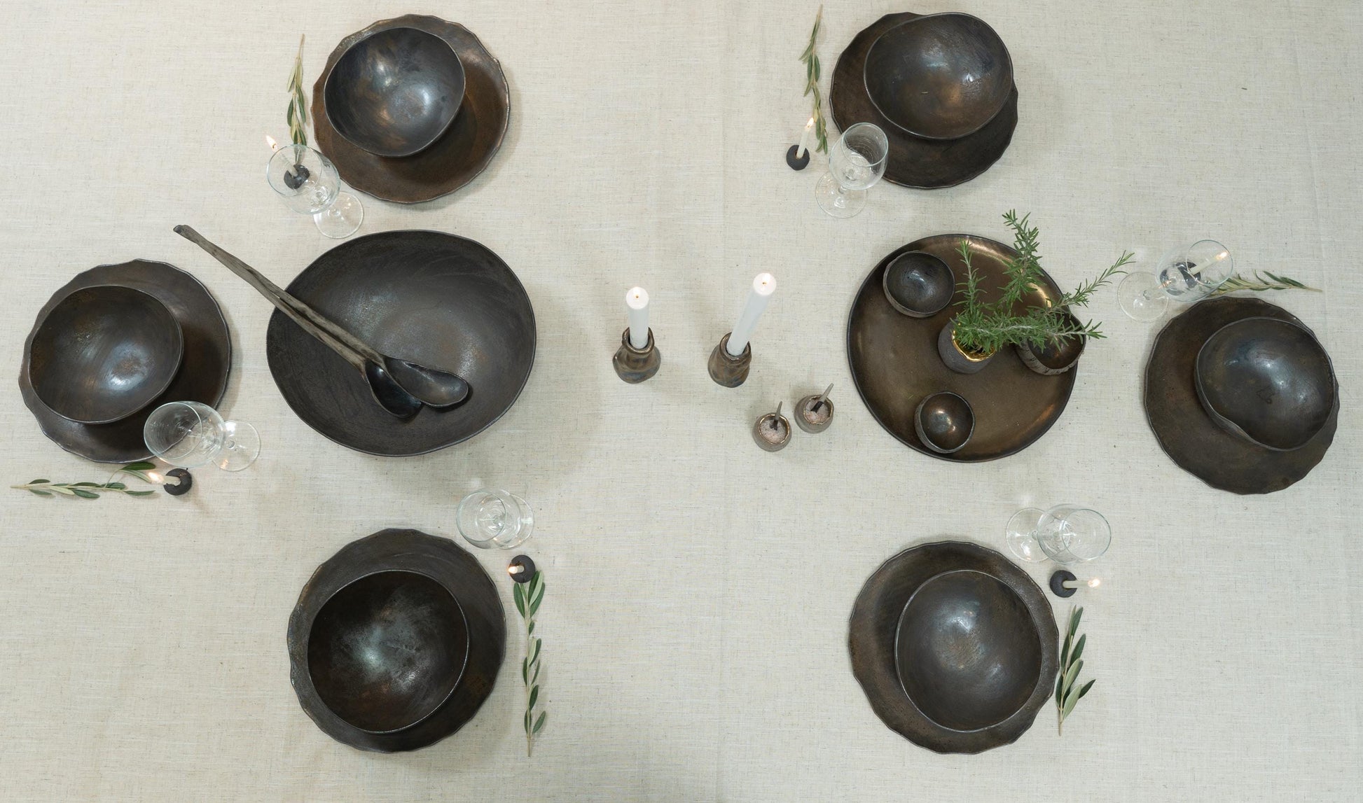 Up view of pottery dish set with stem glass and minimalist candle