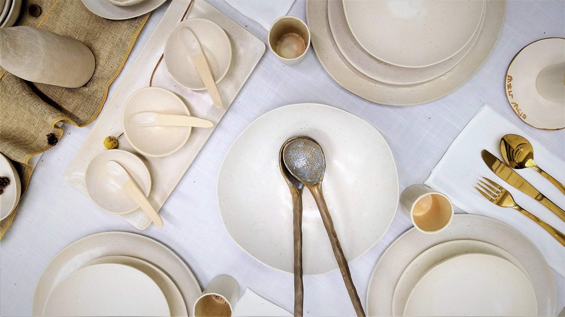 Plates, bowls, and cups arranged on linen