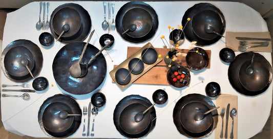 Several black ceramic dish on a table