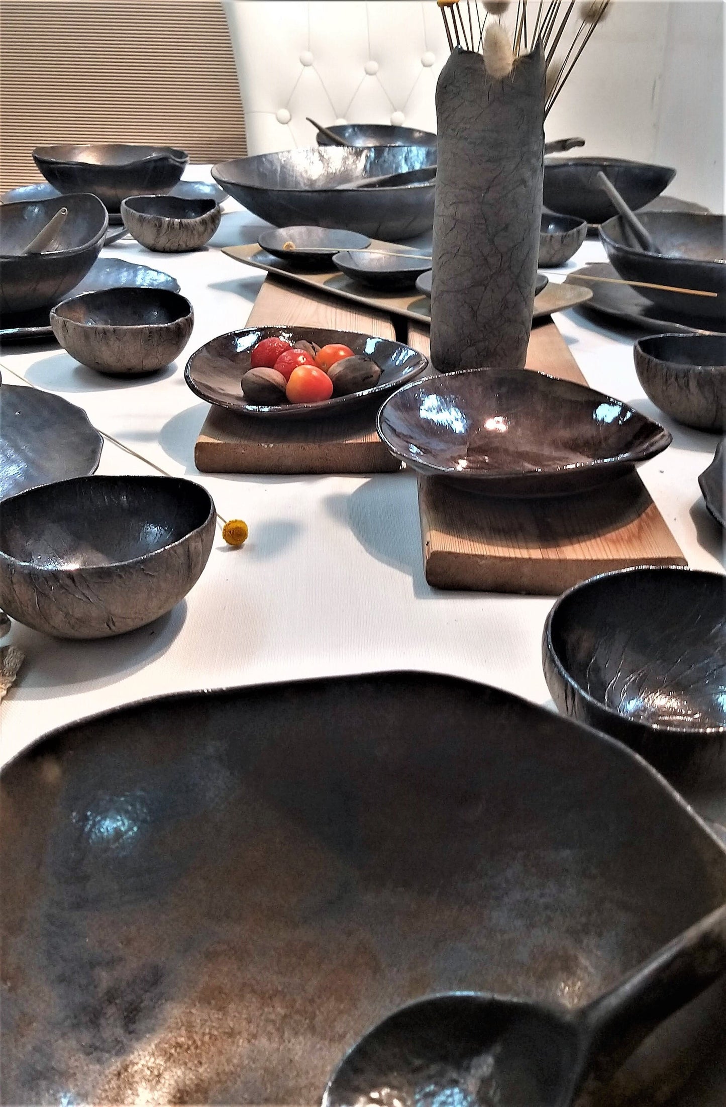 A set of rich ceramic black dinnerware arranged on a table