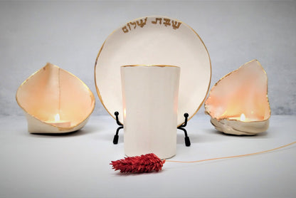 Ceramic kiddush cup and candlesticks with gold rim and Shabbat shalom write in Hebrew