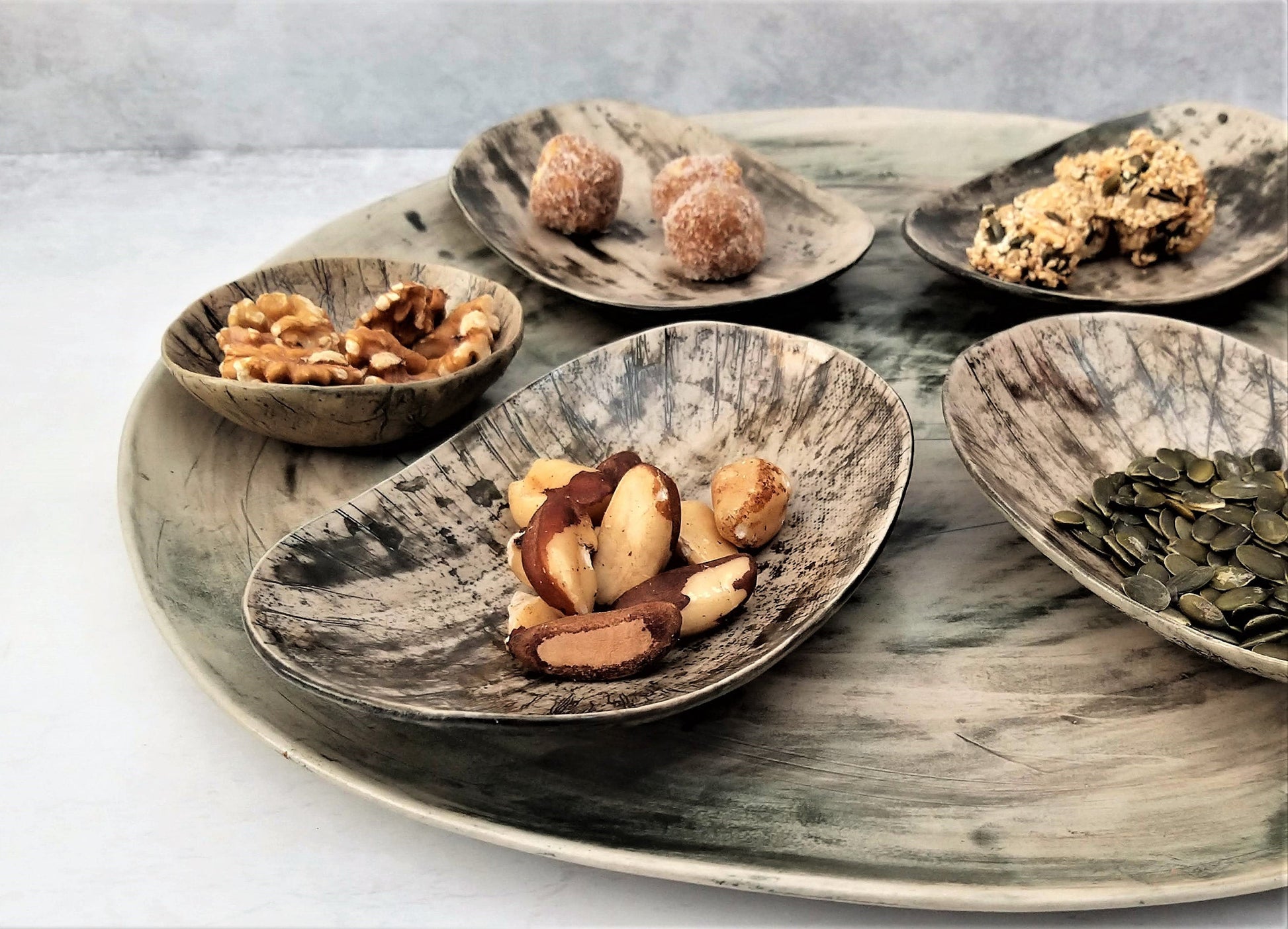 Oval ceramic plates in shades of gray with snacks
