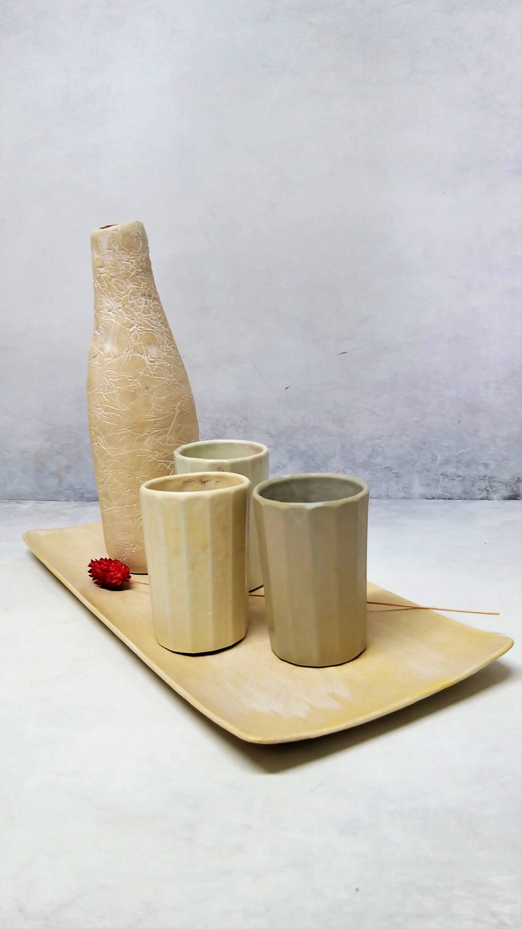 A set of cups, a tray and a bottle in white color made of ceramic